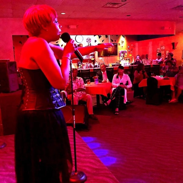 A picture of Traci Braxton singing in an promotional event.